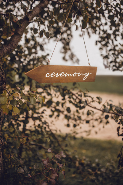 Drewniany drogowskaz Ceremony na tle natury