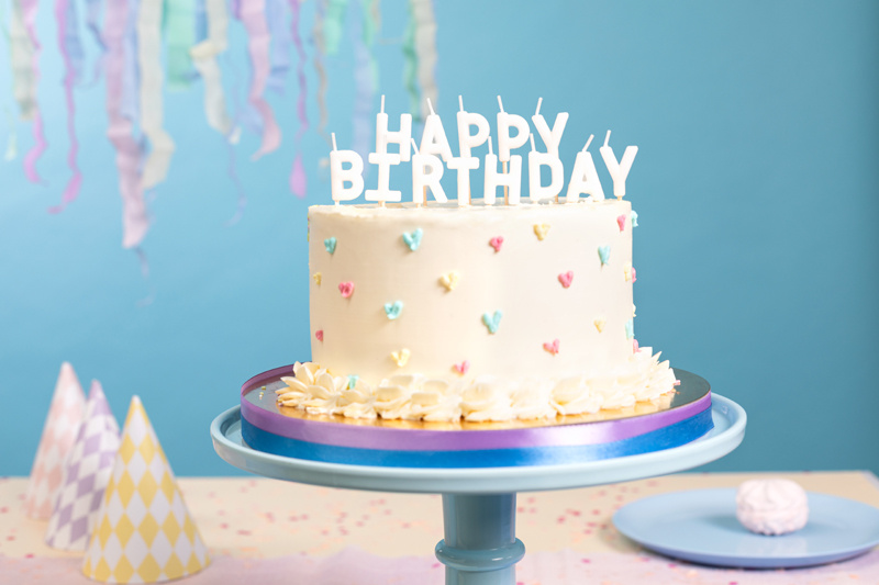 Zbliżenie na białe świeczki urodzinowe Happy Birthday