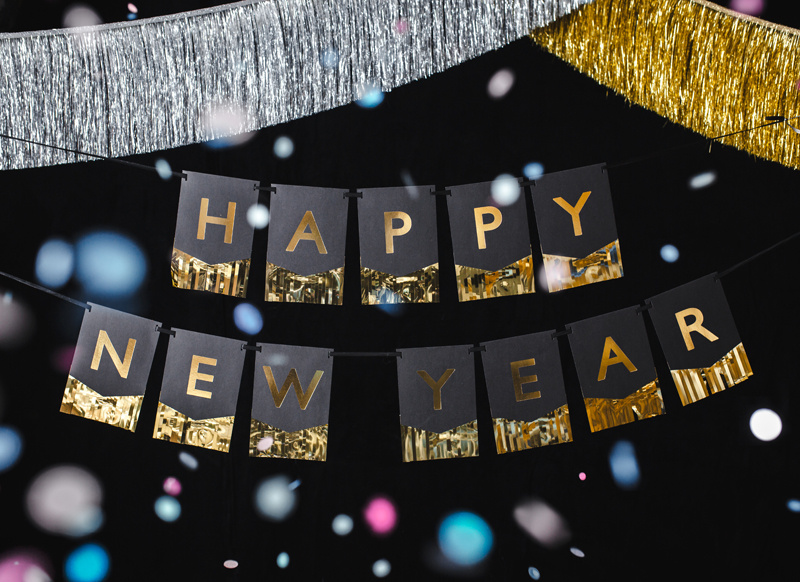 Baner Happy New Year na tle innych dekoracji imprezowych